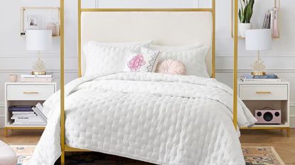 Gold bed posts and white fluffy bedding