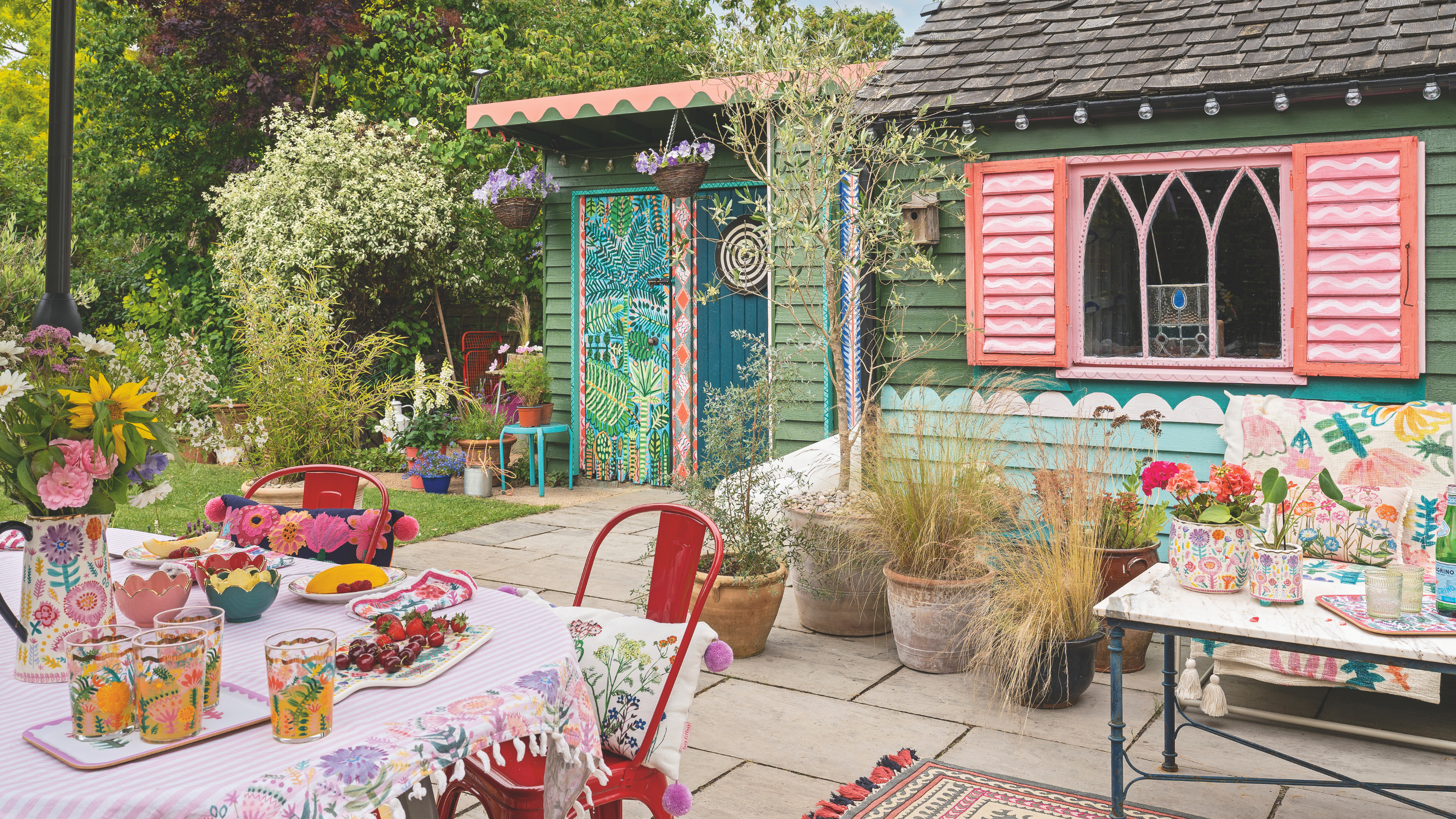 Blue and pink painted shed with potted plants