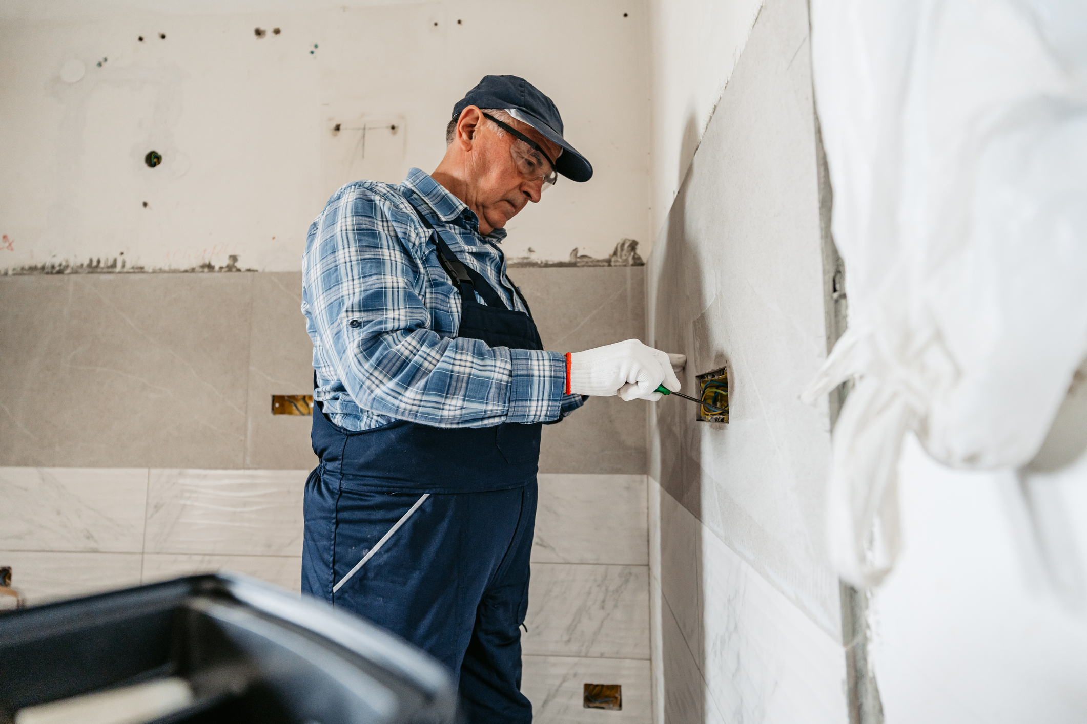 An electrician working on a full bathroom remodel