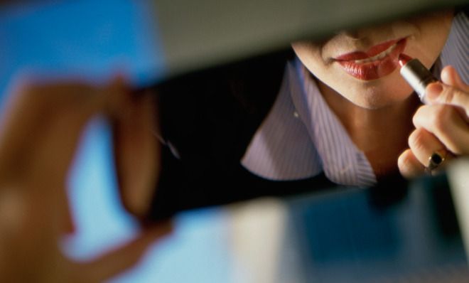 Woman applying lipstick