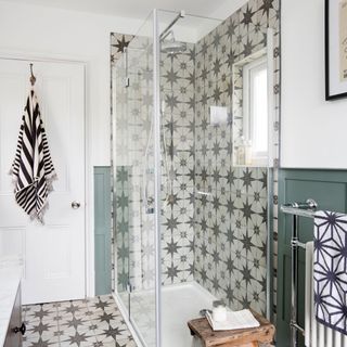 Bathroom with bold patterned floor and wall tiles and a shower cubicle