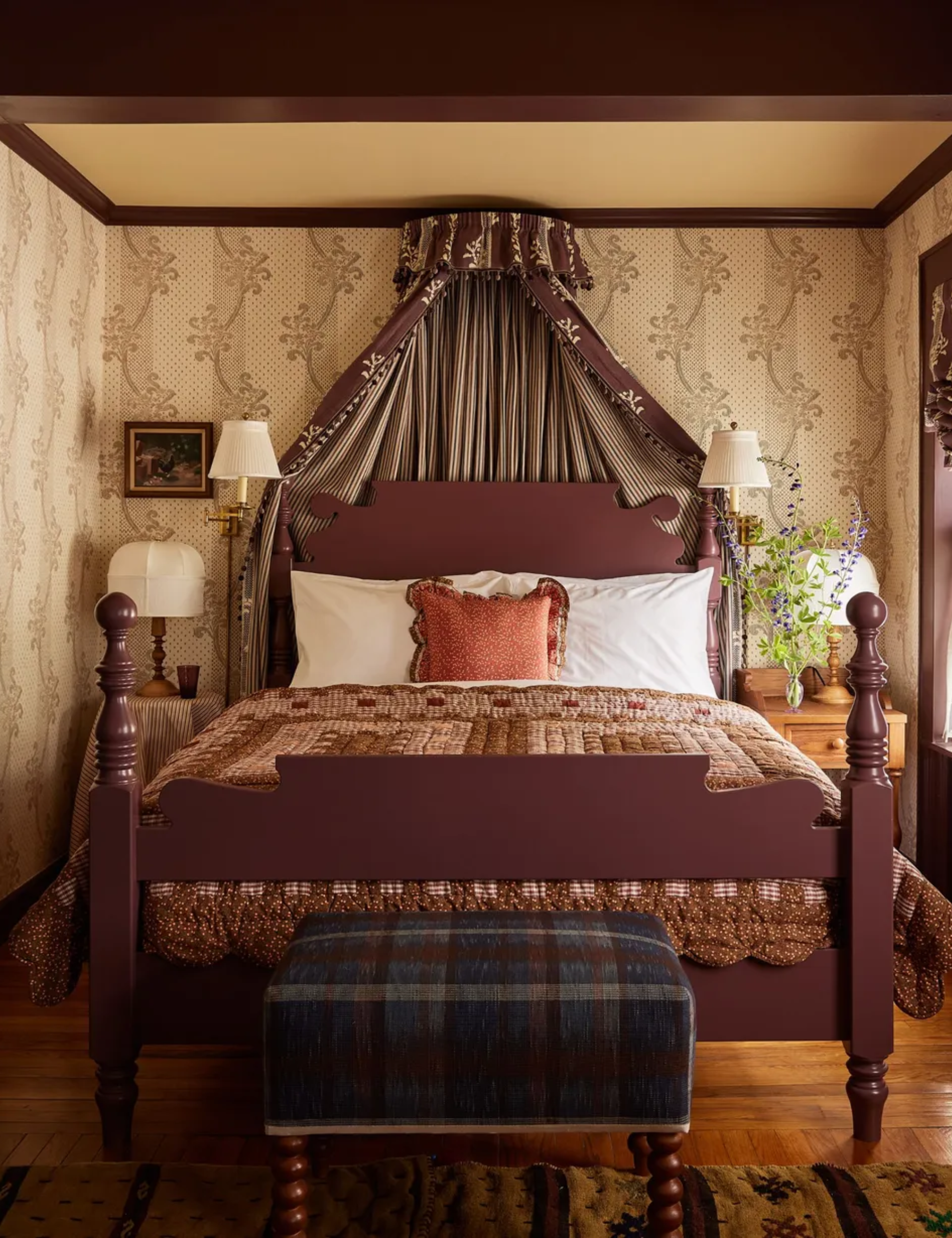 The Six Bells bedroom with floral wallpaper, patchwork quilt and bed coronet. Photography by Kate S. Jordan