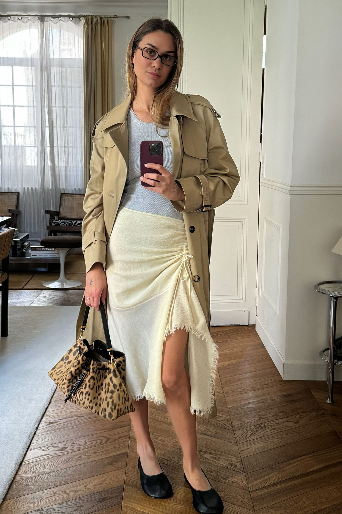 A woman wearing trench coat and a knee-length skirt