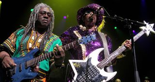 Blackbyrd McKnight and Bootsy Collins jam onstage with Bootsy wearing a purple sparkly suit and matching hat, playing his star-shaped custom bass