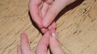 Tying a knot at the end of a thread