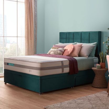 Silentnight Lift Replenish hybrid mattress blue bedroom with a teal bed with an exposed mattress