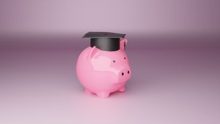 A mortar board on a piggy bank against a purplish background.