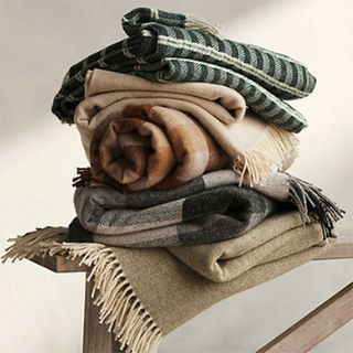 pile of outdoor blankets on a bench