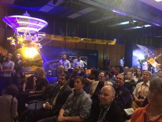 Members of the Cassini team and other JPL employees watch the final minutes of the Cassini mission, next to a full-scale model of the spacecraft.