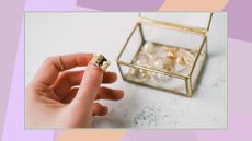 A woman's hand holds a gold ring on the background of a transparent jewelry box with accessories on a colorful background