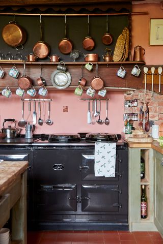 Aga in a kitchen of an old home with copper pans hanging above