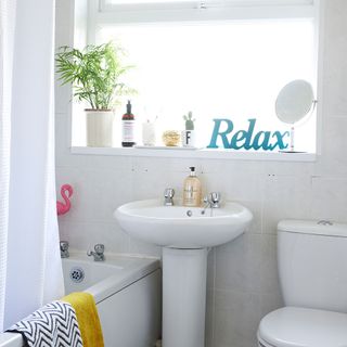 bathroom with bathtub and white washbasin