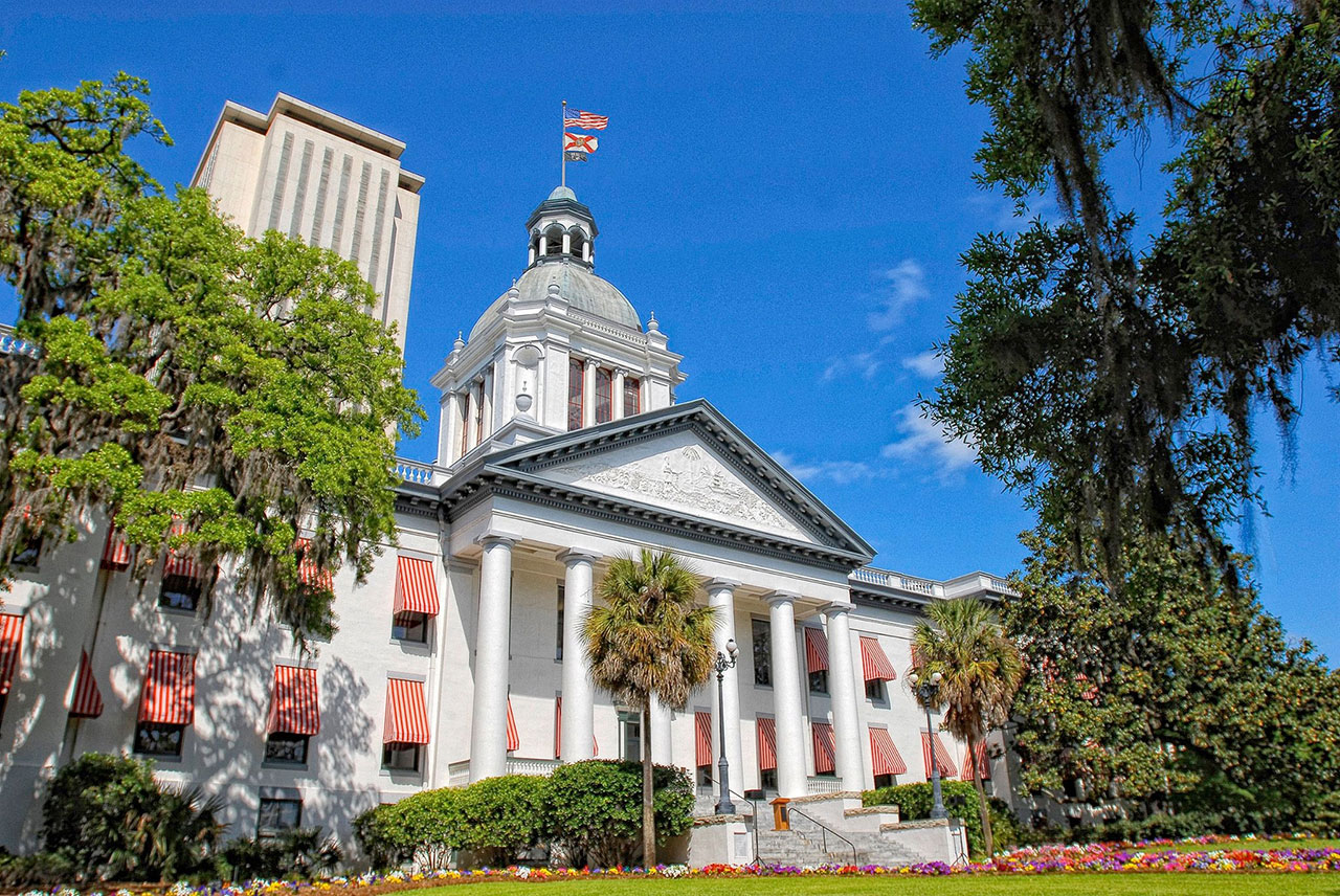 the state capital complex in tallahassee, showing a greek-style building with an american flag flying on top