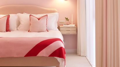 an all-pink Barbiecore bedroom with pink and red bedspread, pink walls, white curtains, and walls painted in Lick paint