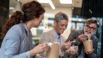 Colleagues eat lunch together in an office