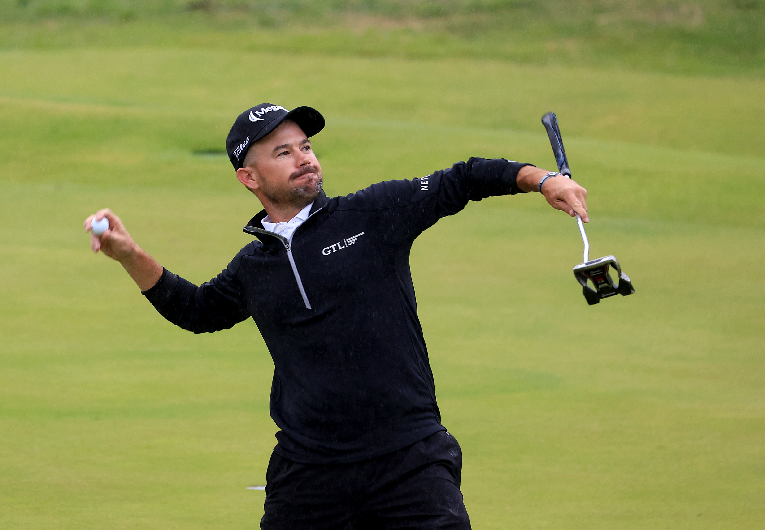 Brian Harman throws a golf ball into the crowd