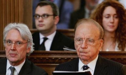 Rupert Murdoch, right, sits in front of former News of the World editors Andy Coulson (not shown) and Rebekah Brooks in 2005: Coulson and Brooks are two of eight former News Corp. journalists