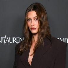 Hailey Bieber wearing an oversize brown suit at the Vanity Fair x Saint Laurent x NBCUniversal "Oppenheimer" Film Toast held on March 8, 2024 in Los Angeles, California.