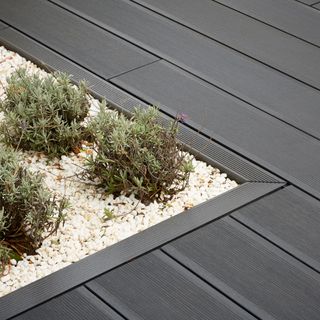 composite decking ideas with grey floor and plants on white stone