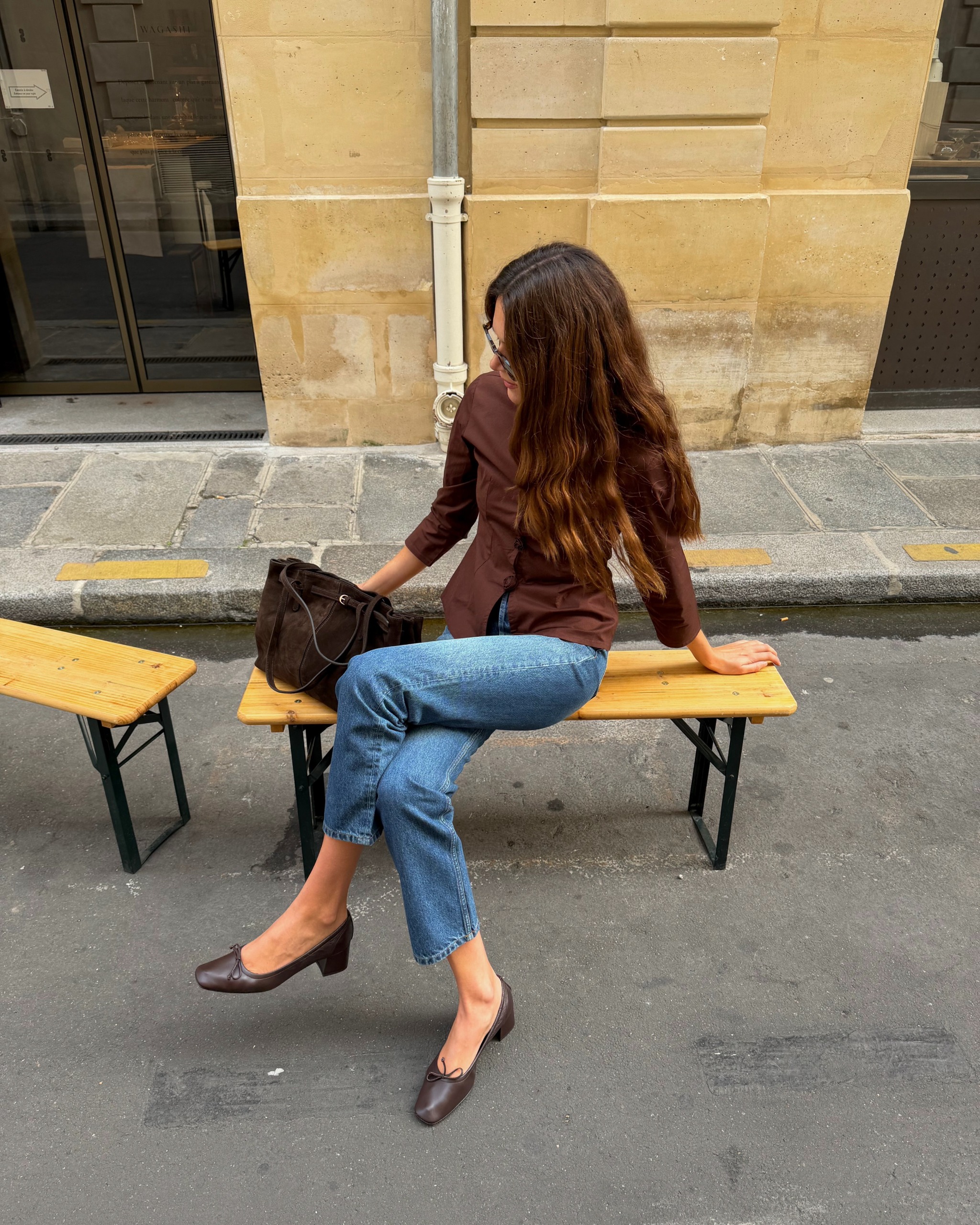 Woman in jeans and heeled ballet pumps.