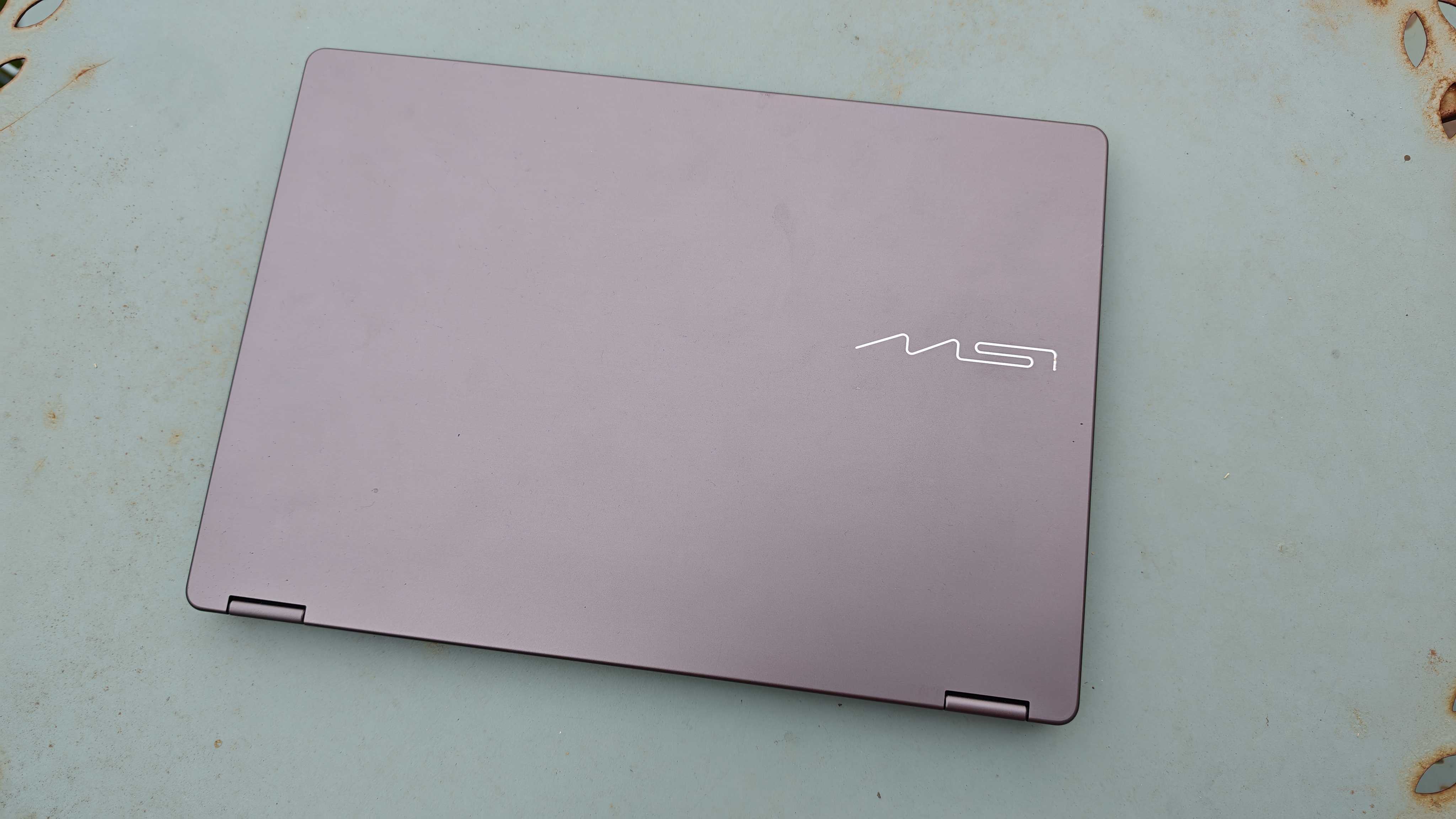 A silver MSI Prestige 14 Flip AI+ laptop on a garden table