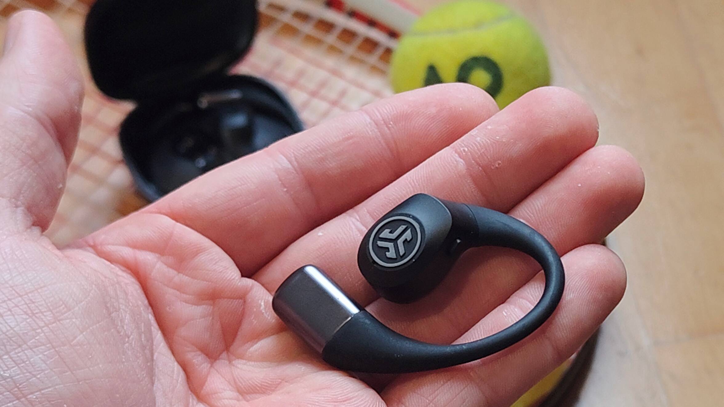 The JLab Epic Open Sport on a tennis racquet.