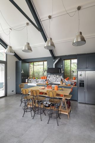grey kitchen with large industrial pendant lights in vaulted ceiling