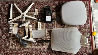 All the parts of the Ergonomic Chair Pro, laid out on a carpet.