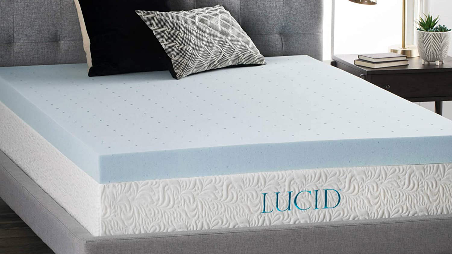 The Lucid 4 Inch Gel Mattress Topper placed on a white mattress and dressed with pillows