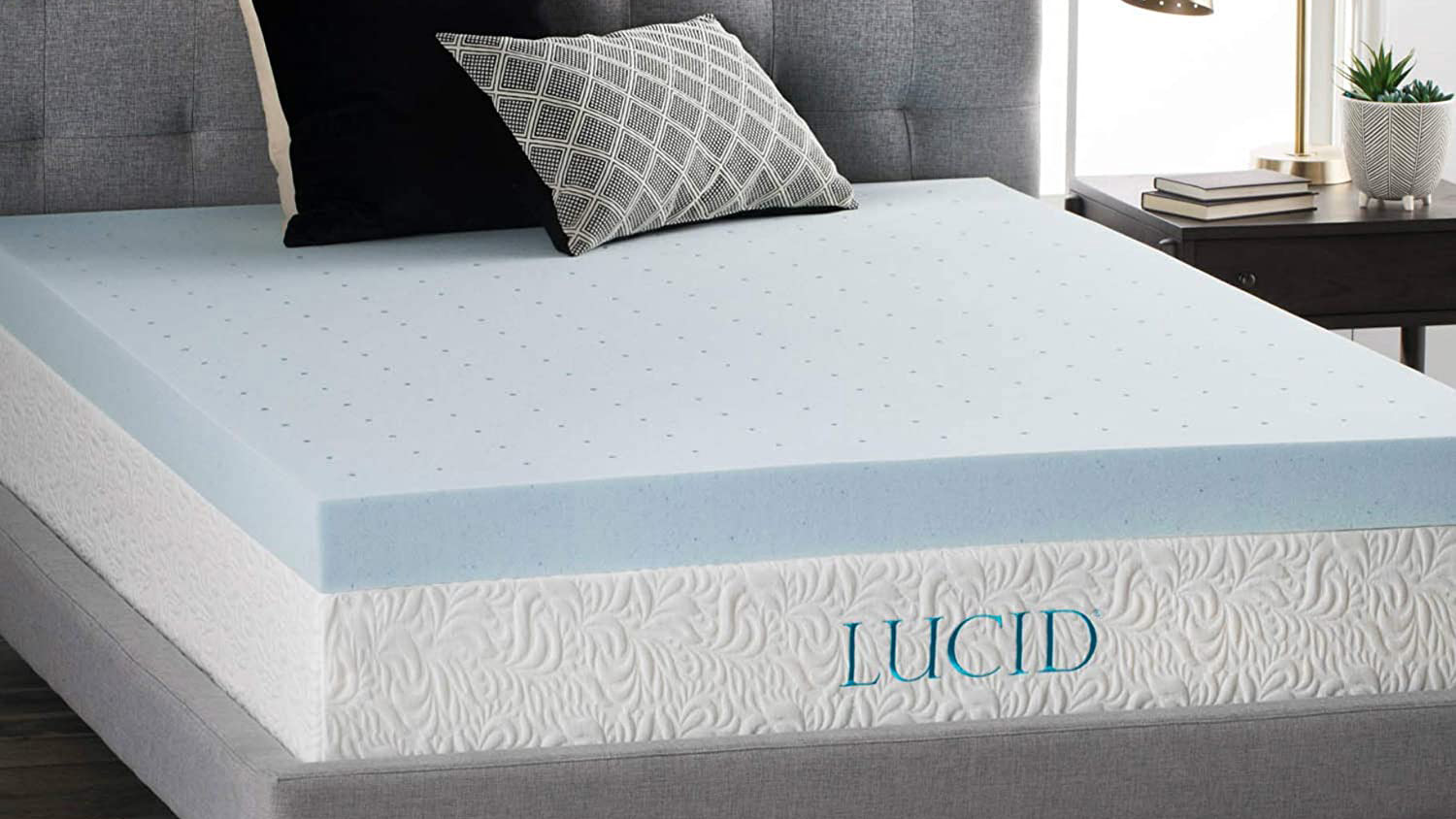 The Lucid 4 Inch Gel Mattress Topper placed on a white mattress and dressed with cushions