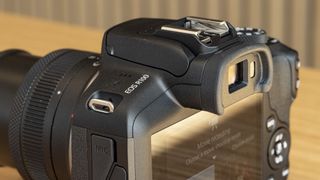 Canon EOS R100 camera on a table closeup of model name