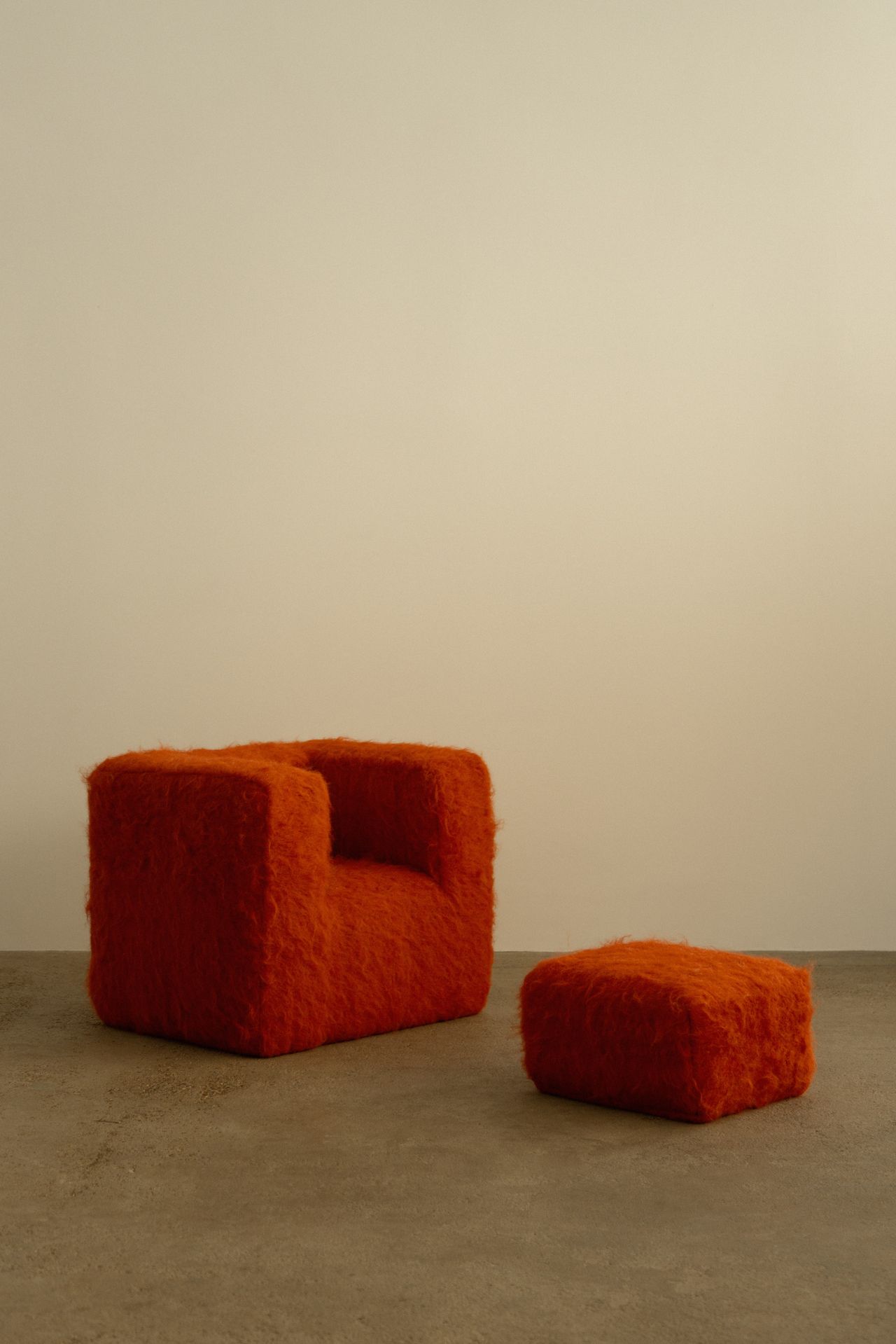 A series of textile creations with an abstract, textural wool feel sit in an industrial showroom alongside iconic modernist designs.