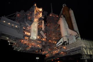 Lights on Launch Pad 39A at NASA's Kennedy Space Center reveal space shuttle Atlantis following the rollback of the rotating service structure, or RSS, the night before launch. The RSS provides protected access to the orbiter for crew entry and servicing