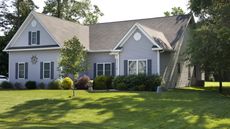 A suburban home with a lush, green front lawn in the summer