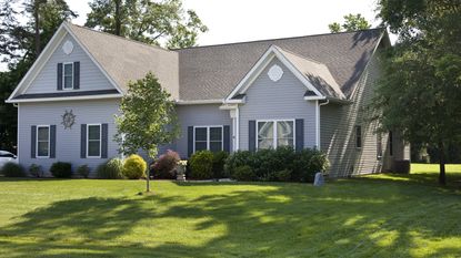 A suburban home with a lush, green front lawn in the summer