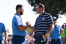 Jon Rahm of Team Europe and Scottie Scheffler of Team United States shake hands on the 15th green during the Friday morning foursomes matches of the 2023 Ryder Cup at Marco Simone Golf Club
