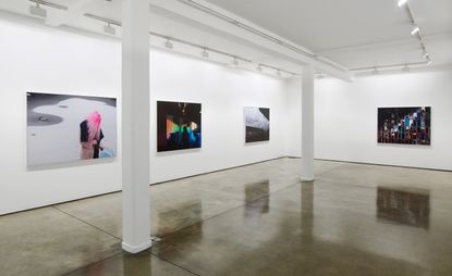 An exhibition wall with abstract paintings