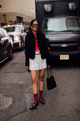 Woman at Fashion Week walking in the street wearing loafers,