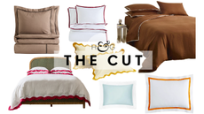 Bed sheets with borders in various color combinations, including chocolate brown, oxblood, orange, ice blue, and raspberry, pictured against a white background.