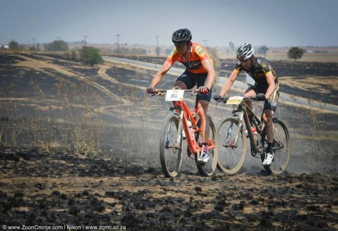 Team Westvaal Bells Cycling's Nico Bell leads Team RE:CM's Waylon Woolcock through a burnt field during the last 10 kilometre of the MTN Ride Crater Cruise