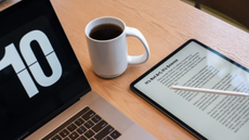 Tablet showing PDF document next to a laptop and cup of coffee