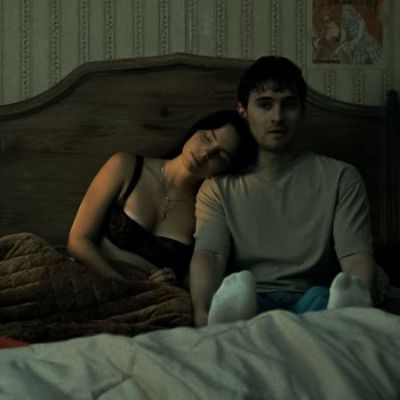 nikki rests her head on bear in bed as he looks scared in a still from obsession