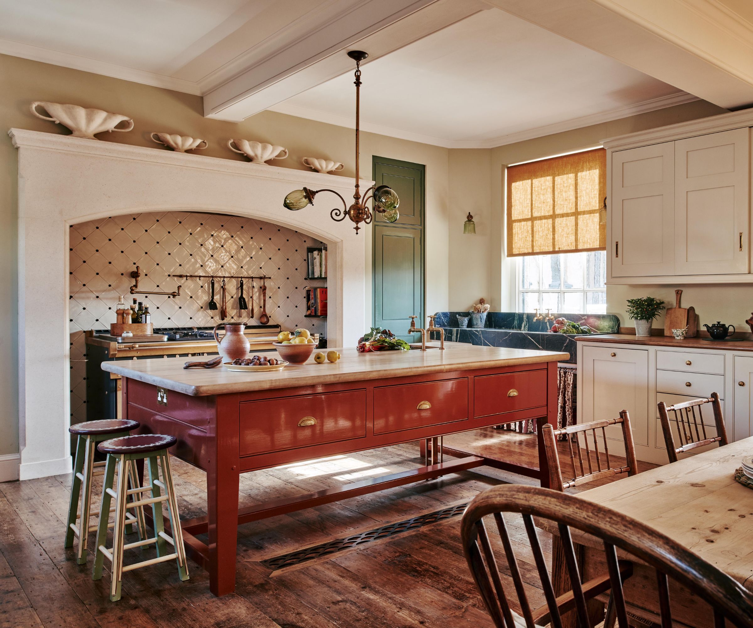 A large country kitchen with white cabinets and a terracotta freestanding island