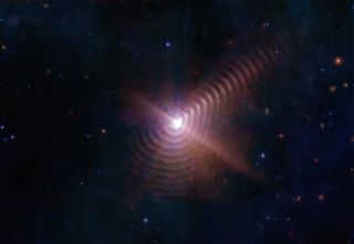 a bright white point of light in the center with purple brown 'ripples' or 'rings' emanating from the center.