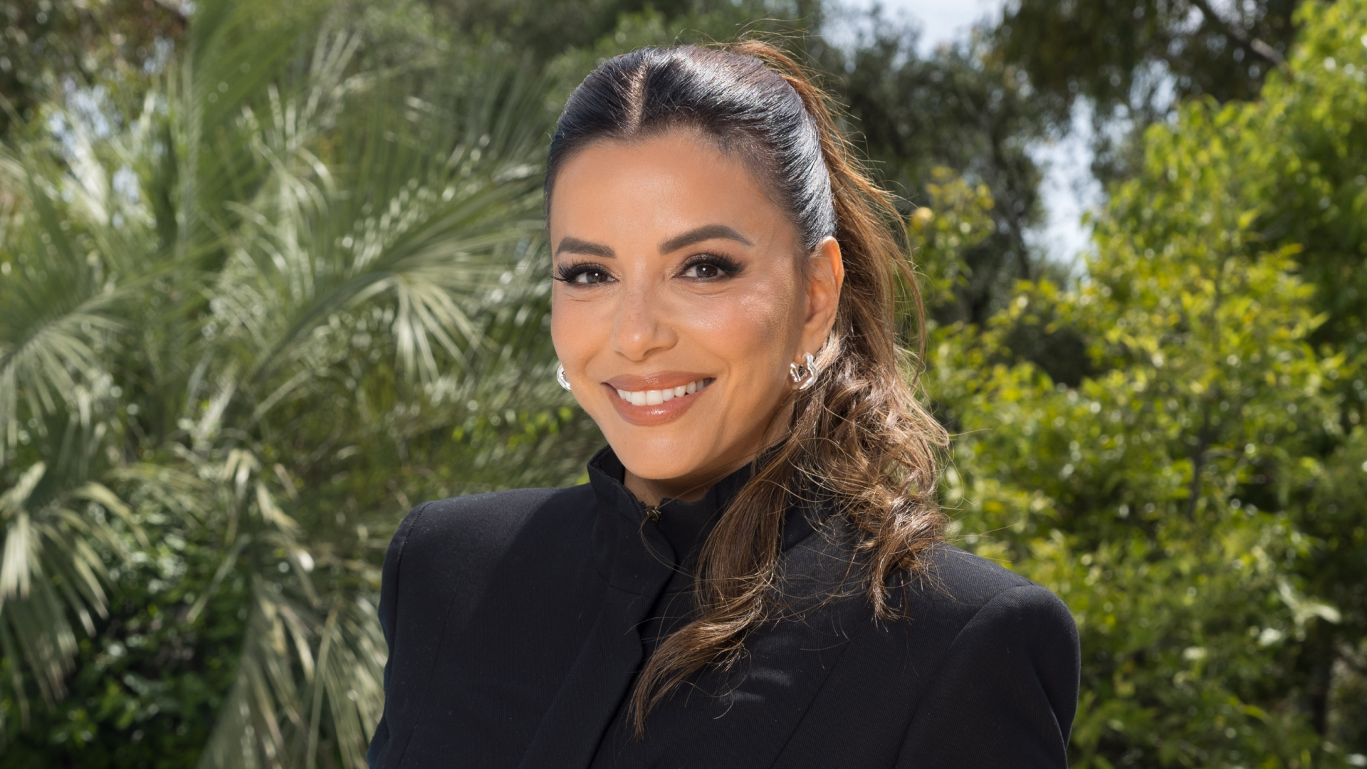 Eva Longoria wearing a ponytail and black blazer