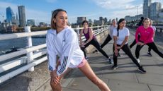 Jessica Ennis-Hill stretching on path in london