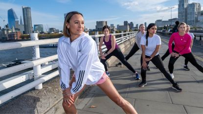 Jessica Ennis-Hill stretching on path in london