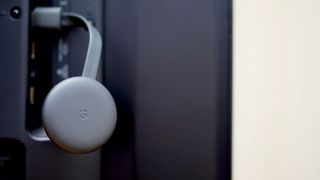How to use Chromecast without wifi: A Google Chromecast device hanging from a USB port on a TV