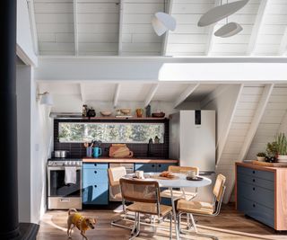 open-plan kitchen diner with blue cabinets and round dining table