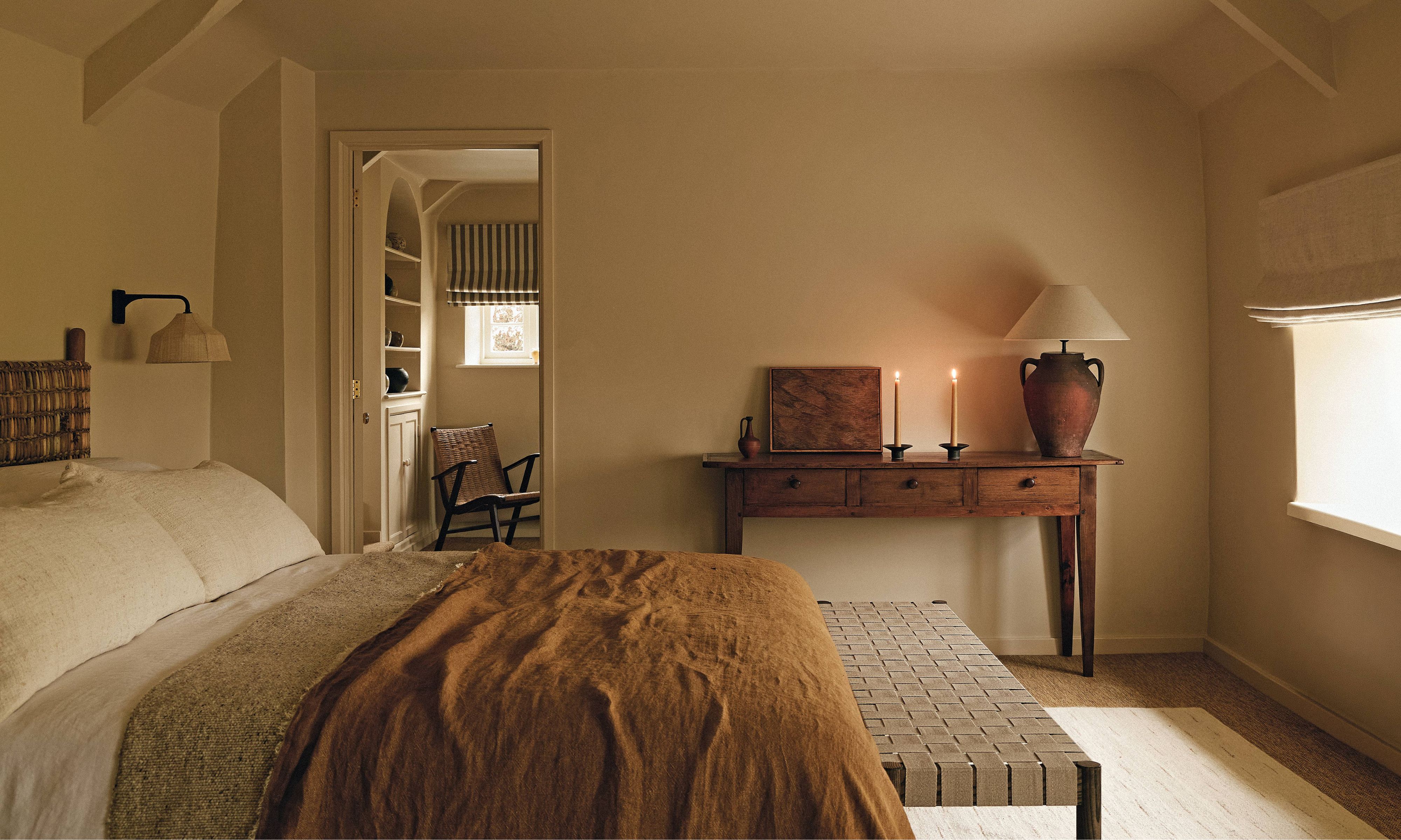 a cozy neutral cottage bedroom with antique furnishings and touches of earthy tones